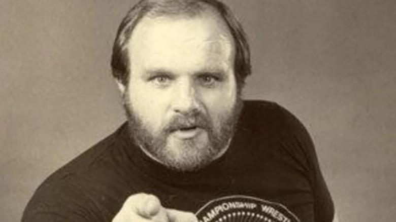 Ole Anderson poses in an old-school photo, pointing at the camera backstage.