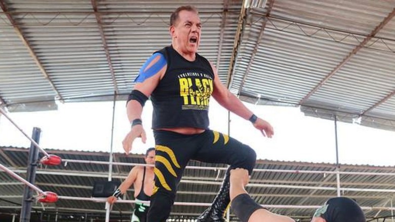 Black Terry stands over a fallen opponent in the ring during a match.