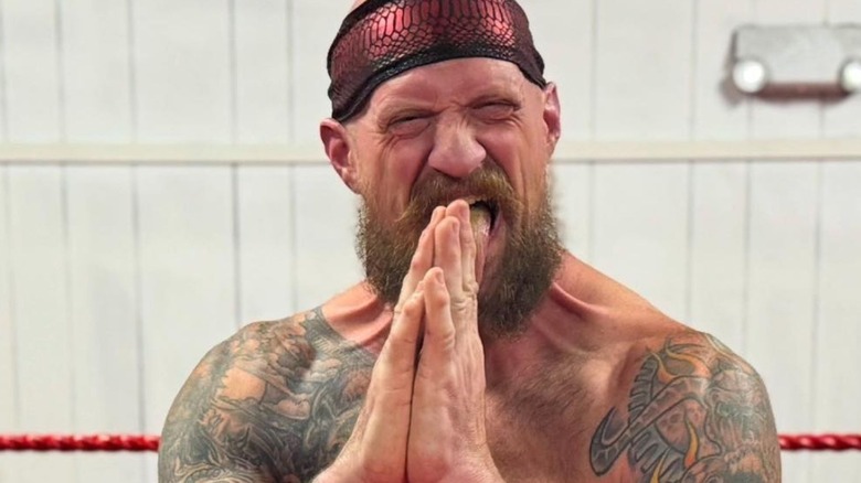 Kevin Nikel poses in the ring, his hands in prayer, while training with Ozark Mountain Wrestling.