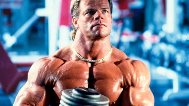 Lux Luger poses for the camera while lifting weights and flexing his muscles.