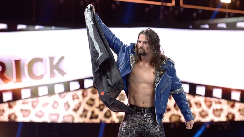 Brian Kendrick poses with a flag in the ring during his entrance on WWE programming.