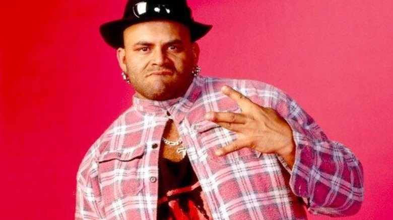 WCW-turned-WWF talent Konnan poses in his nWo Wolfpac shirt for a backstage photoshoot.