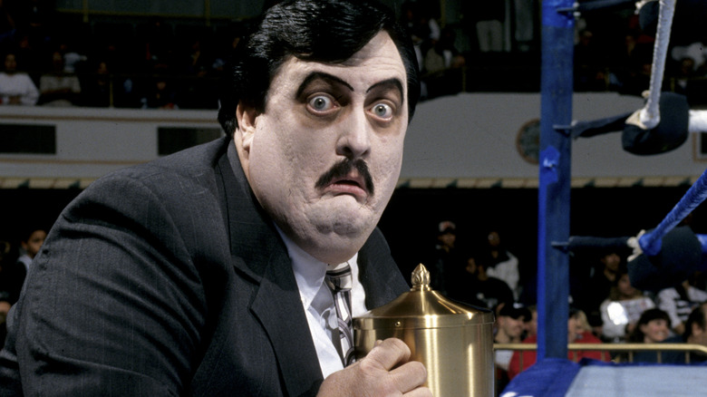 Paul Bearer clutches the urn beside the ring during a WWE event.