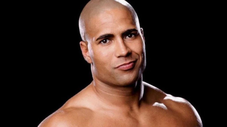 Maven poses in front of a black background with a smirk on his face in a photo posted to WWE.com.