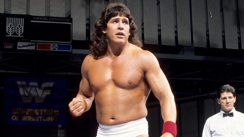 Tito Santana stands in the ring, a referee behind him, before a match in the then-WWF.