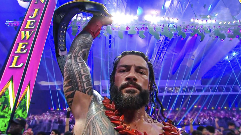 Roman Reigns posing with his title at WWE Crown Jewel