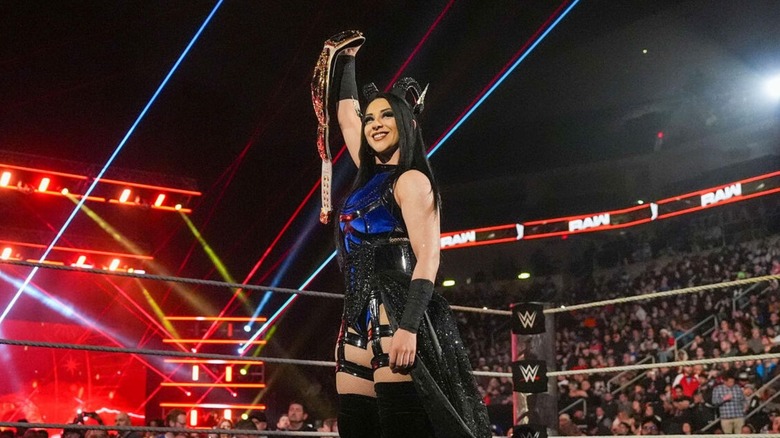 Women's World Champion Stephanie Vaquer holds the title high with a smile on her face before a defense on "WWE Raw."