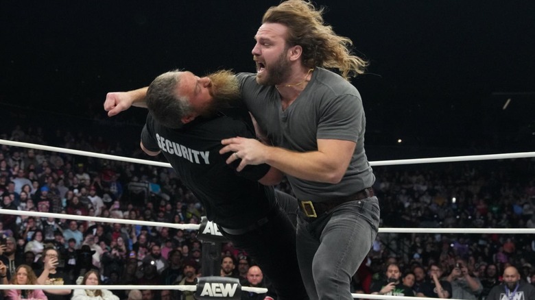 "Hangman" Adam Page lays out a member of AEW security with the Buckshot Lariat.