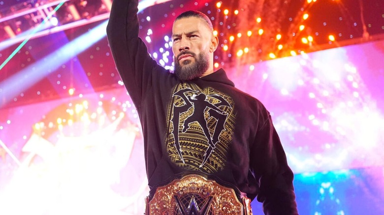 World Heavyweight Champion Roman Reigns stands on the stage, index finger in the air to be 