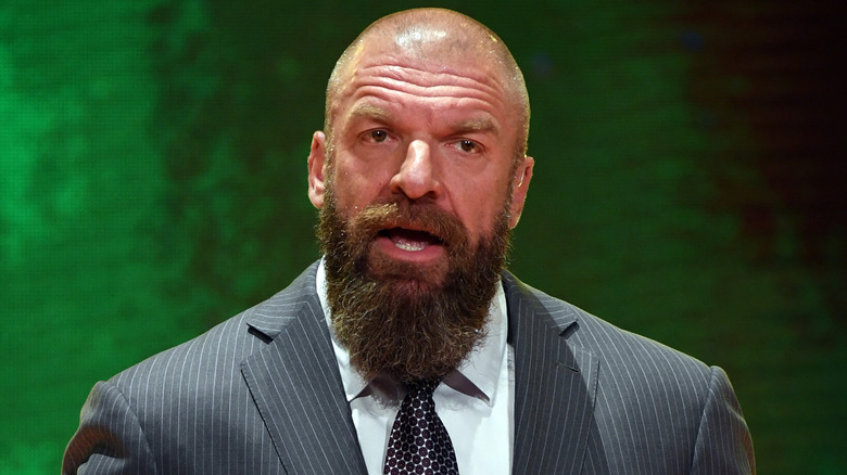 Paul Levesque in front of a green background