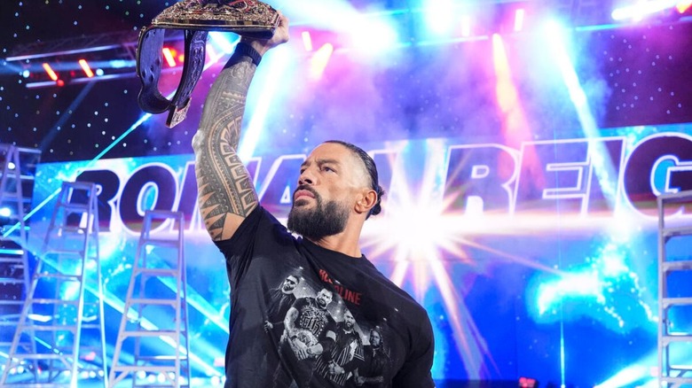 World Heavyweight Champion Roman Reigns poses on the stage as he lifts his title high during the October 5, 2026 episode of 