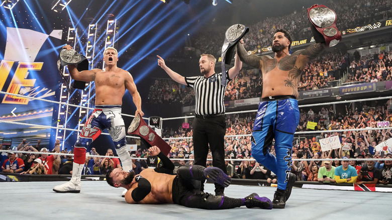 Jey and Rhodes holding up their titles