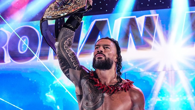 Roman Reigns holding up the WWE World Heavyweight Championship