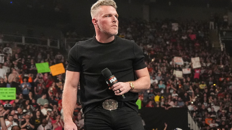 Pat McAfee standing on the commentary desk with a mic on "WWE Raw"