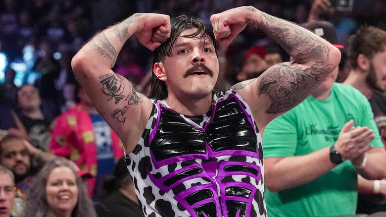 "Dirty" Dominik Mysterio flexes both biceps in front of the crowd.