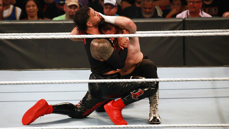 Jey Uso cinches in a headlock on Sami Zayn