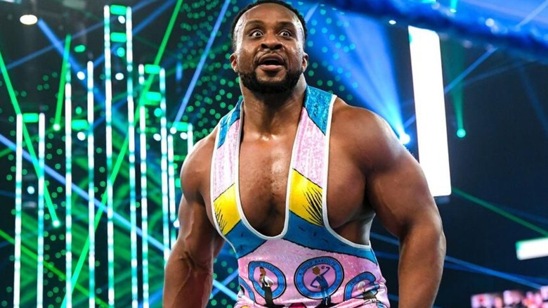 Big E posa para la multitud en el medio del ring durante un combate en