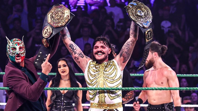 Dominik Mysterio holding his AAA title