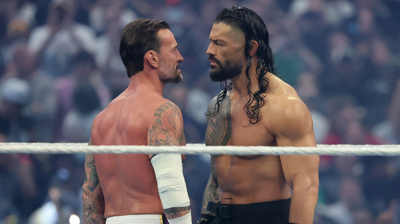CM Punk and Roman Reigns stand face to face