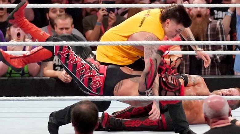Dominik Mysterio flattens Rey Mysterio with a Clothesline.