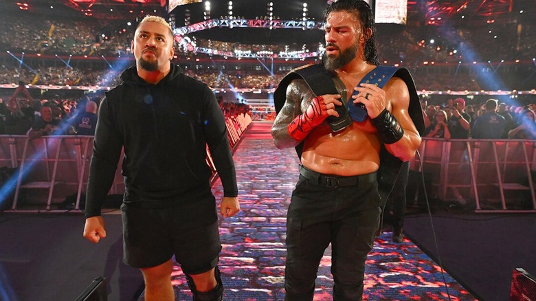 Solo Sikoa stands beside Roman Reigns at WWE Clash at the Castle 2022