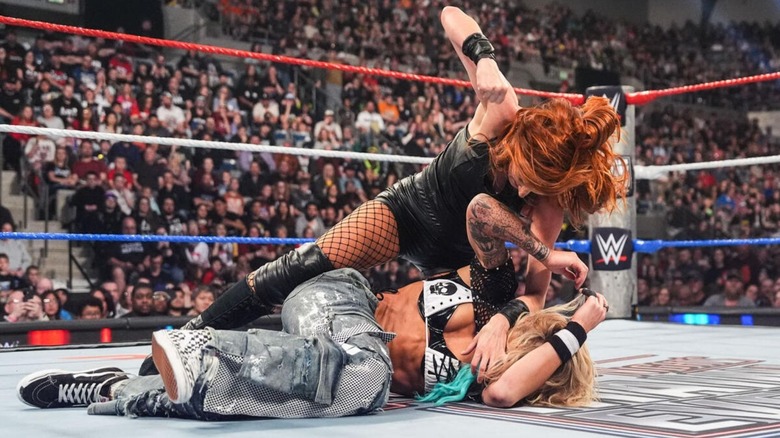 Becky Lynch looks to pummel Sol Ruca in the middle of the ring following the disqualification conclusion of their match at Saturday Night's Main Event.