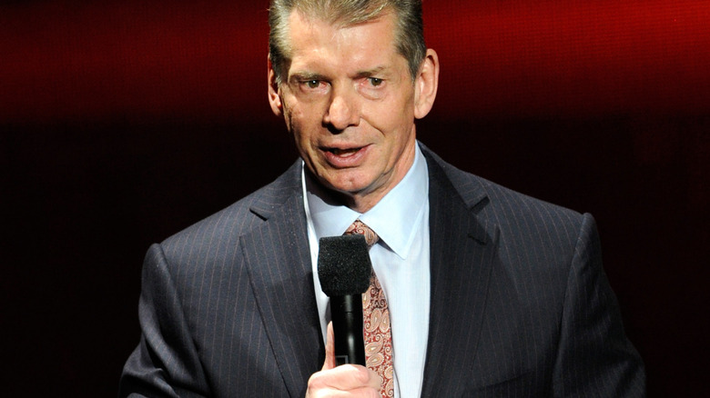 Vince McMahon speaks on the microphone.