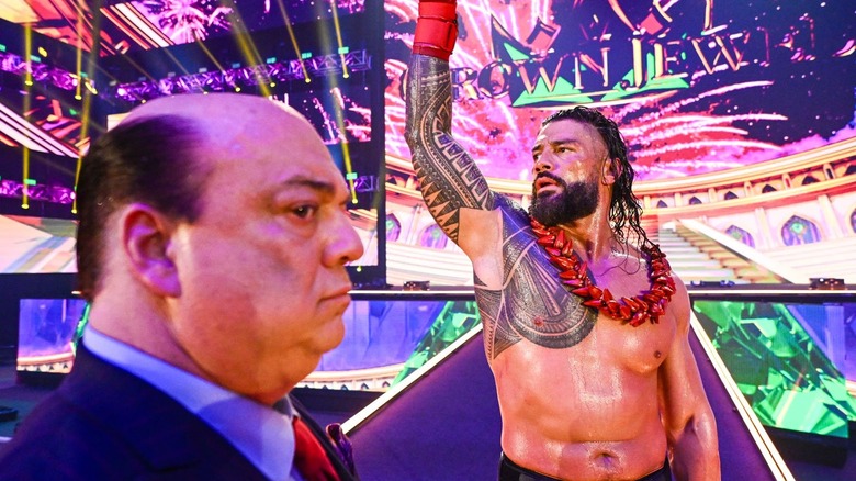 Paul Heyman looks on as Roman Reigns celebrates