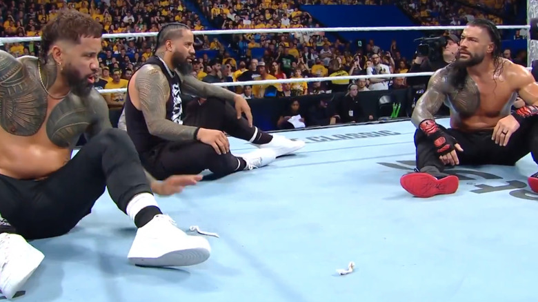 Roman Reigns and The Usos argue in the ring