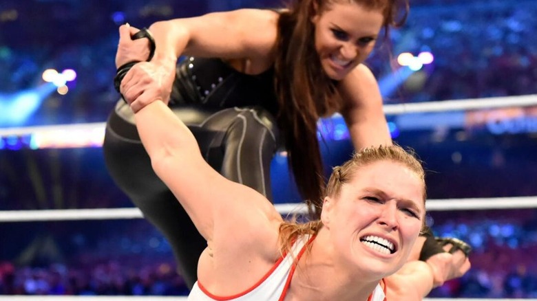Stephanie McMahon holds Ronda Rousey's arms back during their mixed tag team match at WrestleMania 34