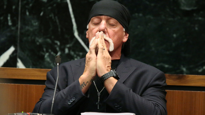 Hulk Hogan brings his hands to his mouth and closes his eyes as he testifies in court.