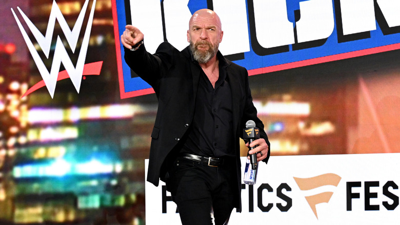 Triple H points to the crowd before speaking at a Fanatics Live event