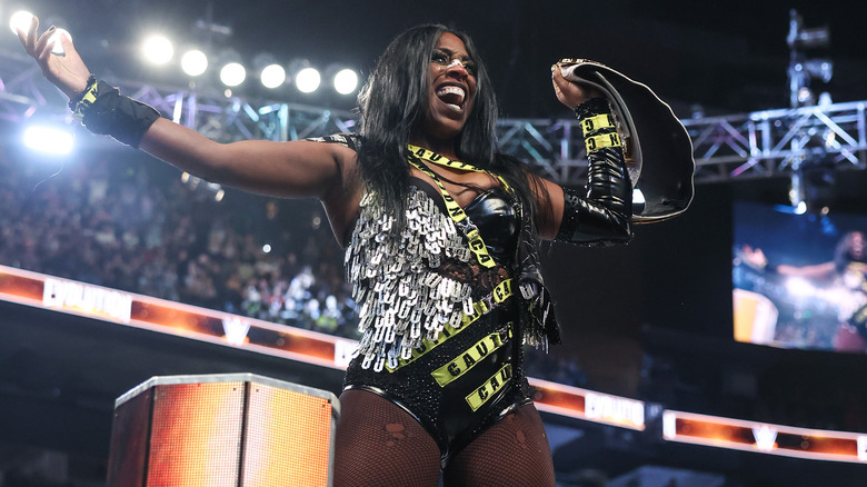 Naomi laughing and posing with the WWE Women's World Championship