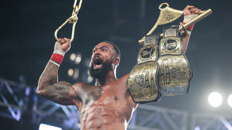 Montez Ford celebrates with the WWE Tag Team Titles.
