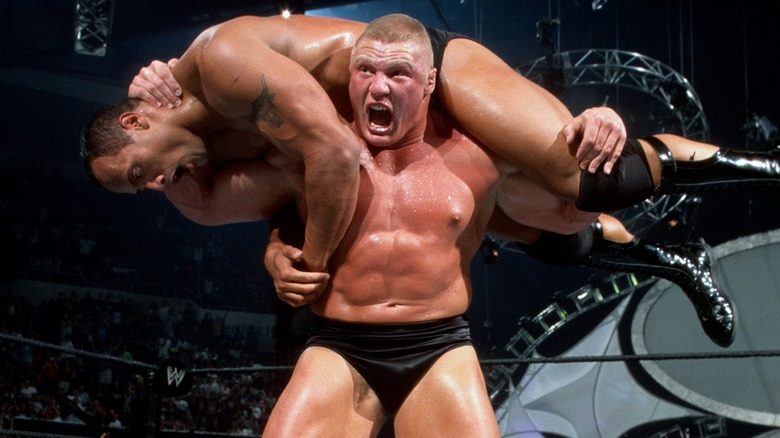 Brock Lesnar holding The Rock on his shoulders at WWE SummerSlam 2002