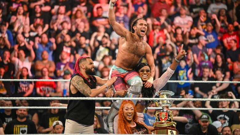 Lash Legend carrying Noam Dar on her shoulder as Oro Mensah and Jakara Jackson celebrate beside them