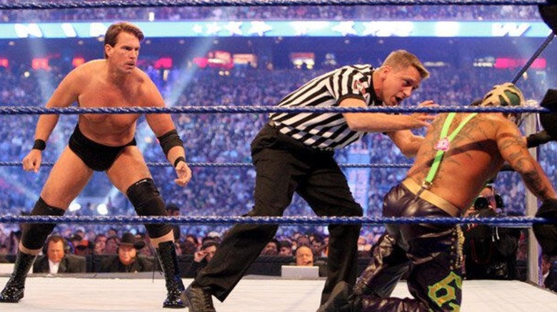 JBL standing by a kneeling Rey Mysterio