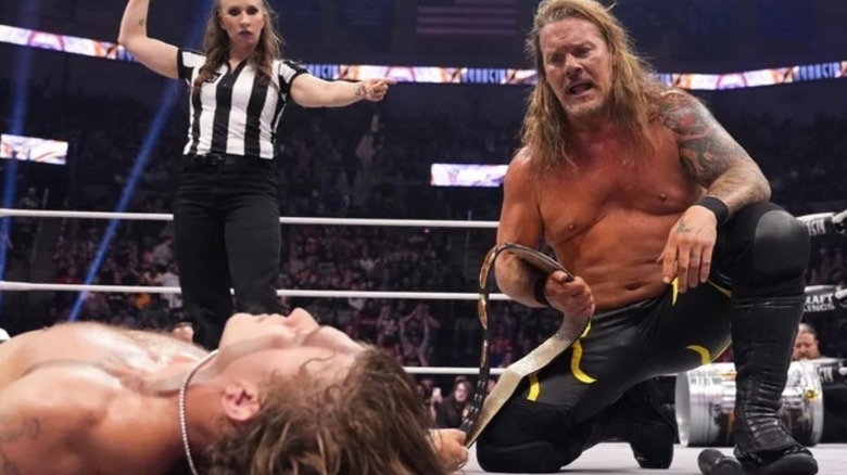 Chris Jericho kneels by HOOK after winning the FTW Championship at AEW Dynasty.