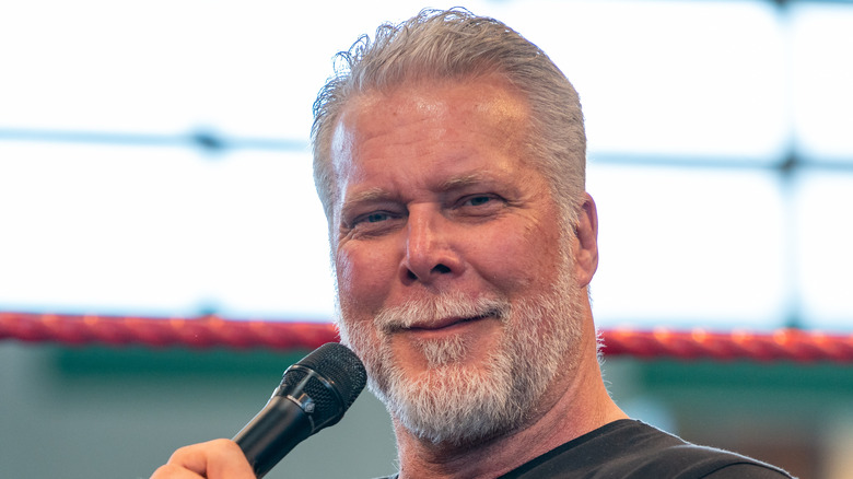 Kevin Nash smiling while holding a microphone