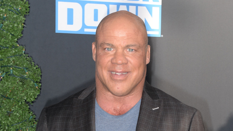 Kurt Angle stands in front of the SmackDown logo