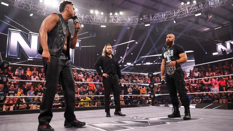 Kam Hendrix cuts a promo on NXT Champion Tony D'Angelo in the ring, as Nakaru looks on, during an episode of 