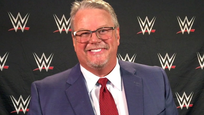 Hall of Famer Bruce Prichard smiles in front on the camera to promote his 