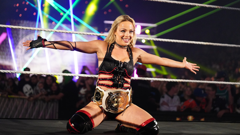 Liv Morgan, arms wide open, but not under the sunlight cause she's indoors