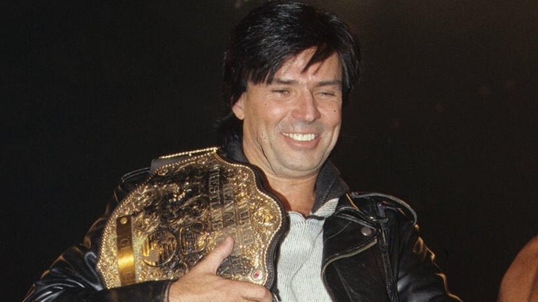 Eric Bischoff with the WCW World Heavyweight Championship across his shoulder during a WCW show.