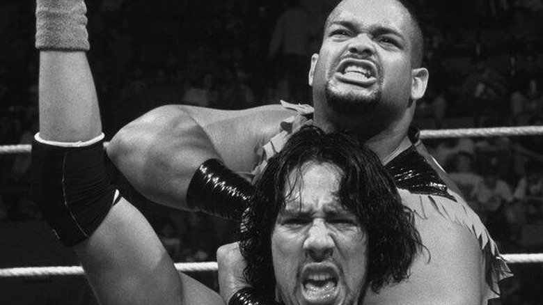 Retired WWE star Savio Vega applies a headlock around JBL during a match