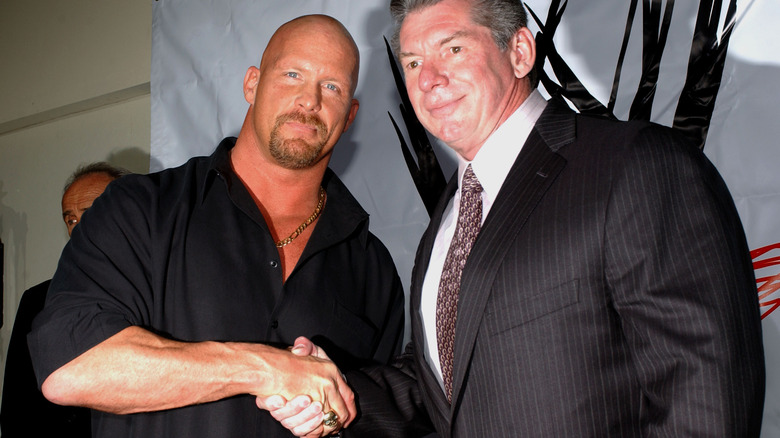 Former WWE CEO Vince McMahon and "Stone Cold" Steve Austin shake hands during a press conference event