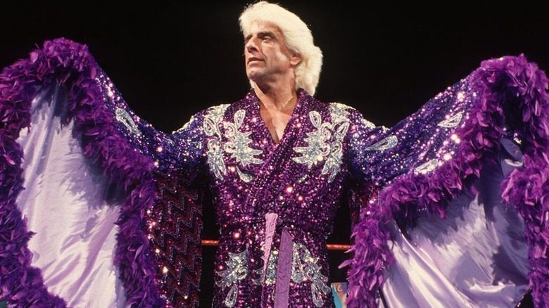 Ric Flair showing off his elaborate purple robe ahead of a match.
