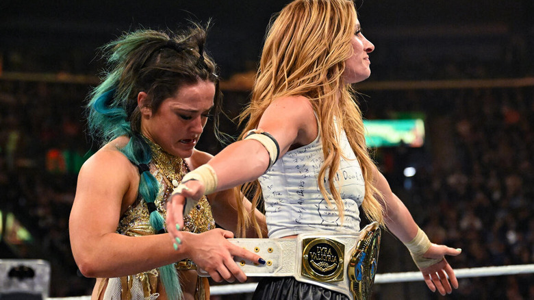 Lyra Valkyria straps the WWE women's Intercontinental title around Becky Lynch's waist after losing it to her at WWE Money in the Bank