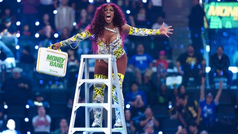 Naomi poses with the Money in the Bank briefcase a top a ladder after pulling it down during the MITB match.
