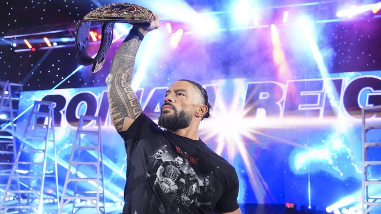 Roman Reigns lifts the World Heavyweight Championship on "WWE Raw"